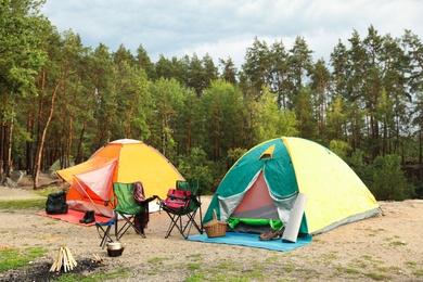 Photo of Camping tents and accessories in wilderness on summer day