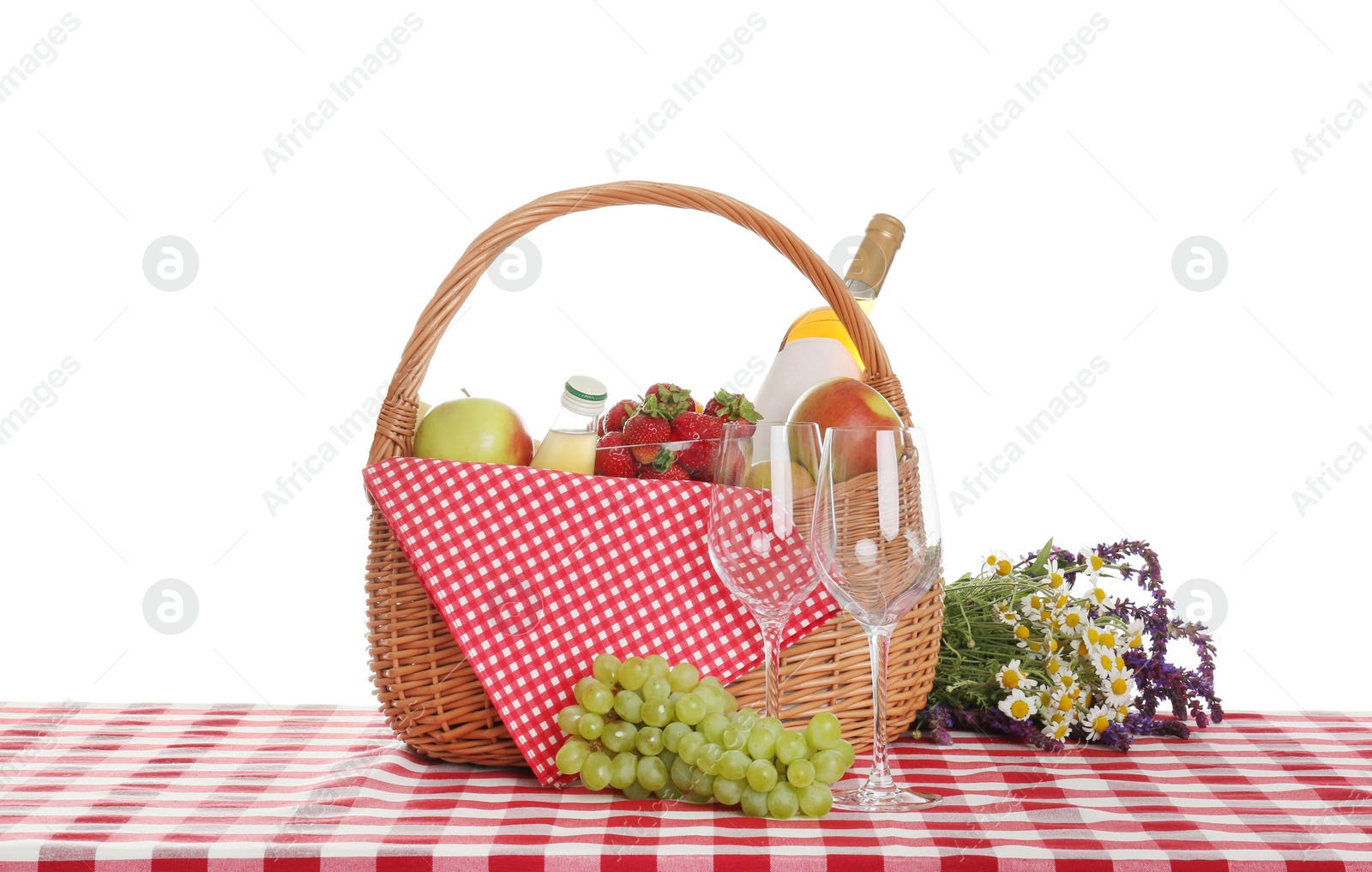 Photo of Picnic basket with wine and food on tablecloth against white background