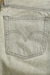 Photo of Stylish light grey jeans, closeup of back pocket