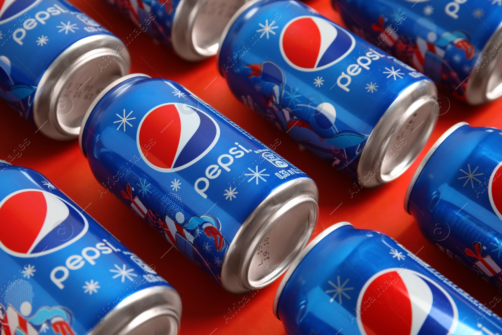 Photo of MYKOLAIV, UKRAINE - FEBRUARY 08, 2021: Cans of Pepsi on red background, closeup