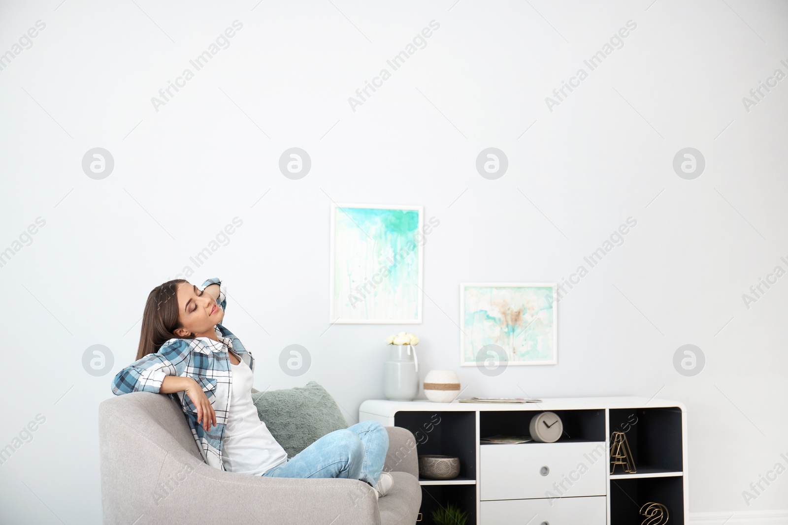 Photo of Young woman relaxing under air conditioner at home