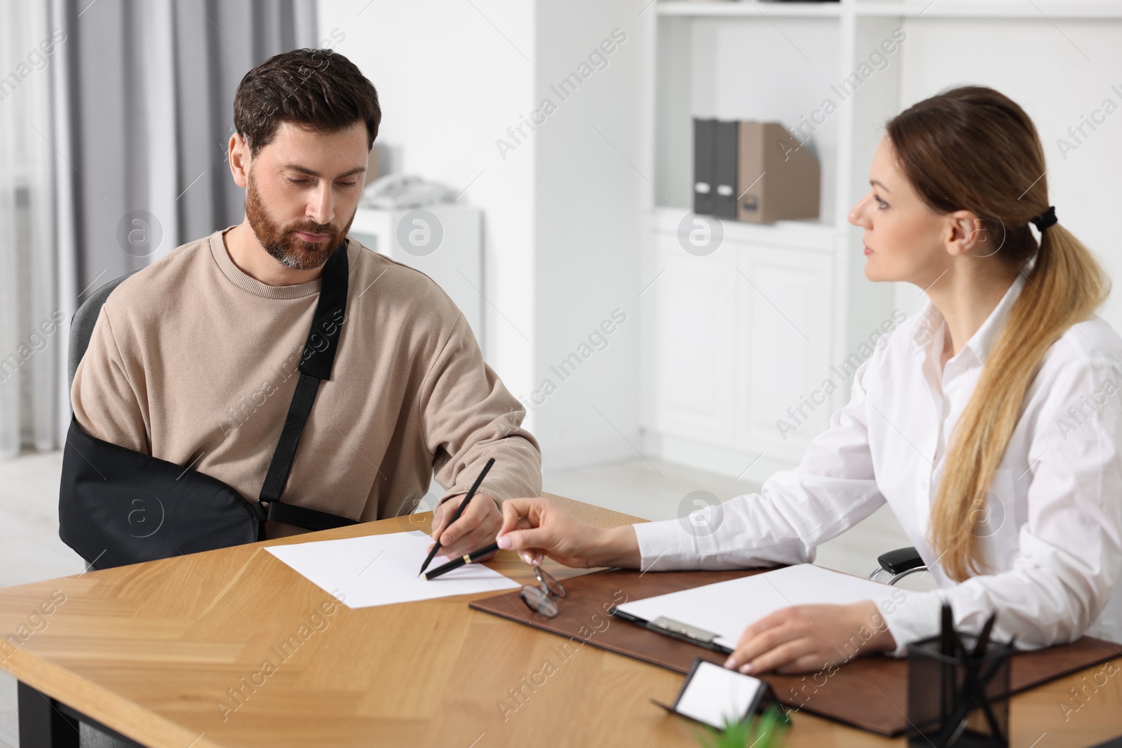 Photo of Injured woman having meeting with lawyer in office