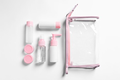 Photo of Cosmetic travel kit and plastic bag on white background, flat lay