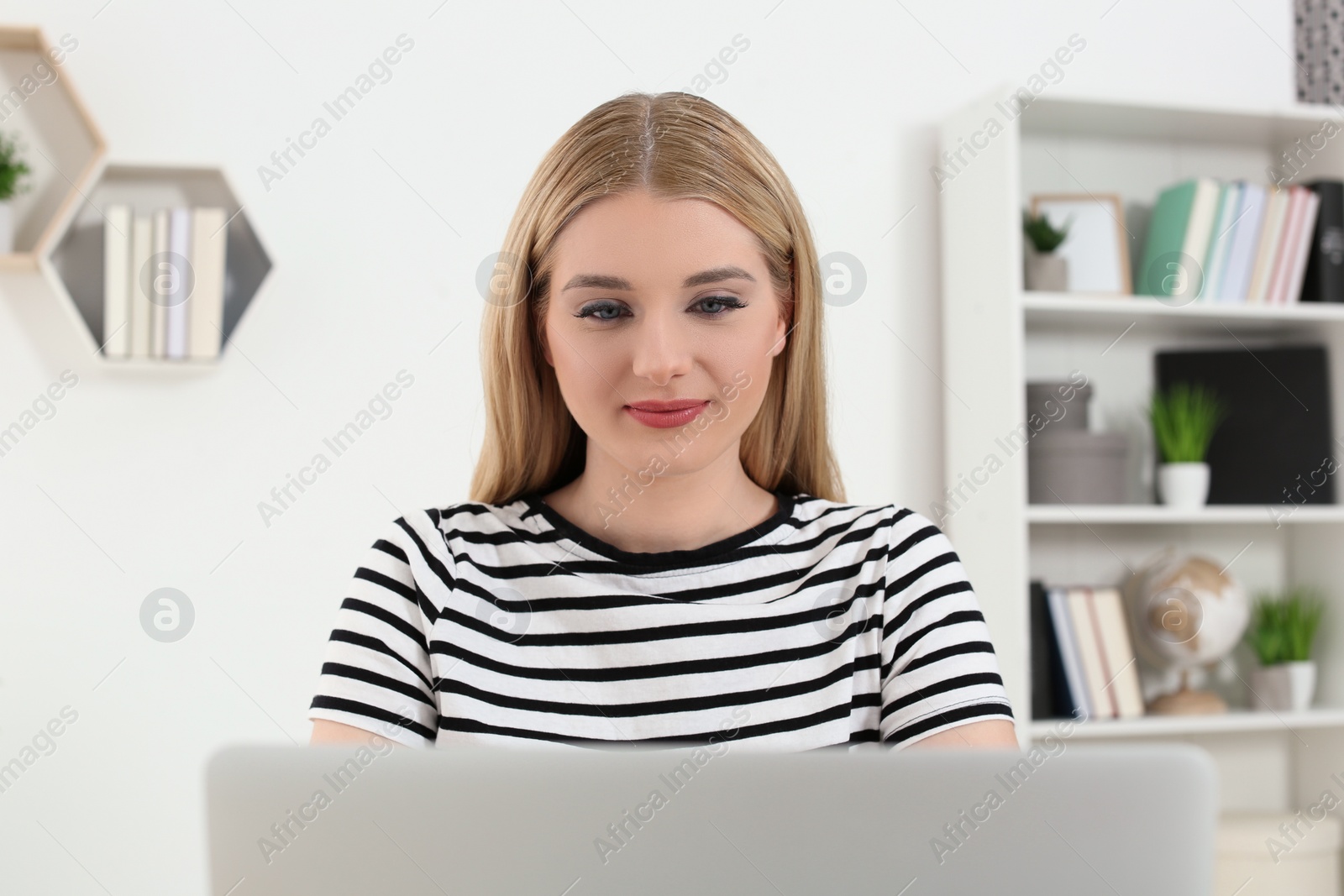 Photo of Home workplace. Woman working on laptop in room