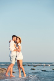 Photo of Young couple spending time together on beach