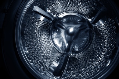 Photo of Empty washing machine drum, closeup. Laundry day