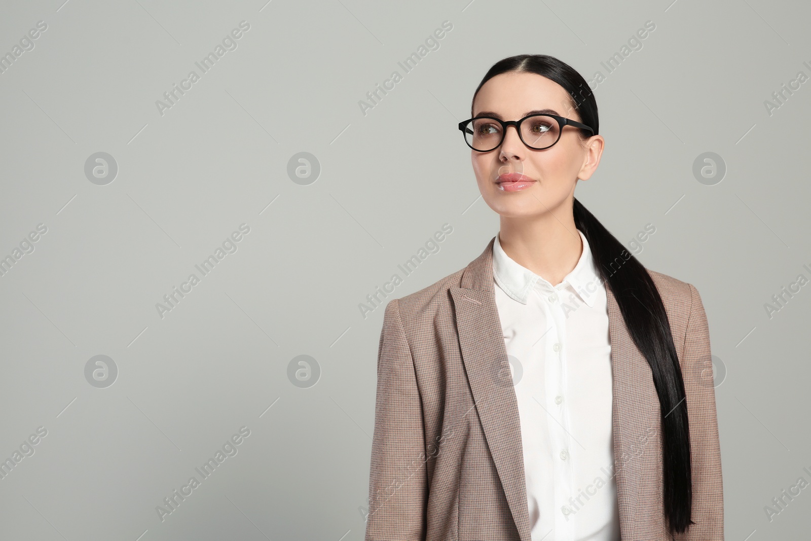 Photo of Beautiful real estate agent in nice suit on grey background, space for text