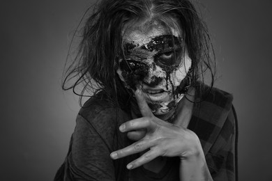 Photo of Scary zombie on dark background, black and white effect. Halloween monster