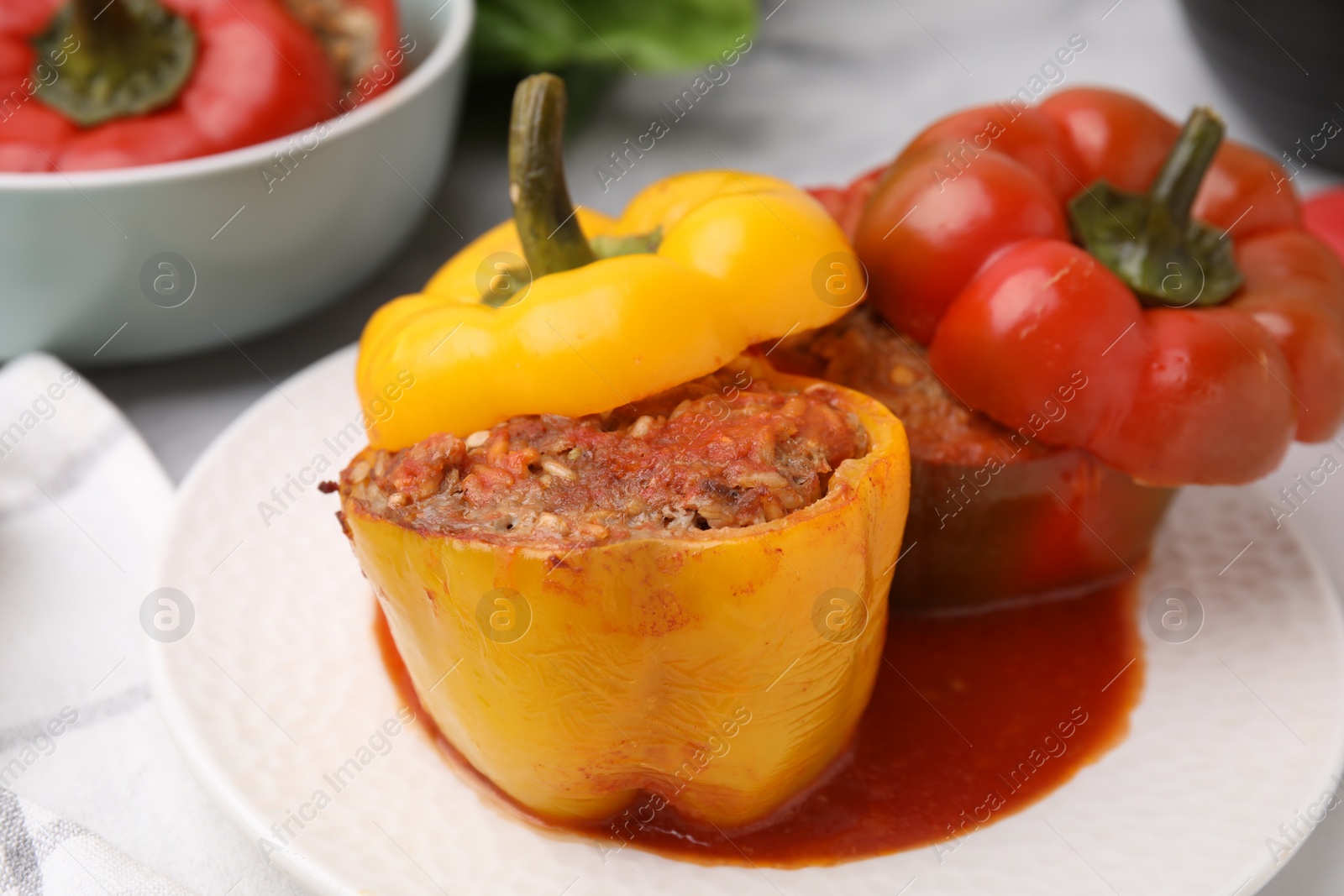 Photo of Delicious stuffed bell peppers served on white marble table, closeup