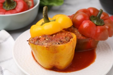 Photo of Delicious stuffed bell peppers served on white marble table, closeup