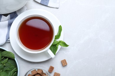 Photo of Composition with cup of hot aromatic mint tea on light table, flat lay. Space for text