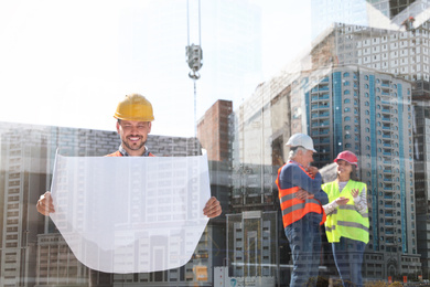 Image of Double exposure of engineers at construction site and modern buildings