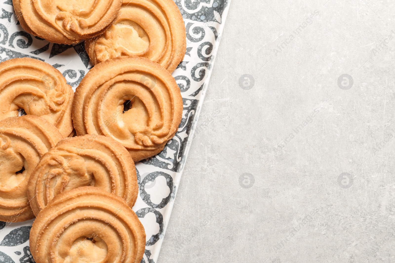 Photo of Plate with Danish butter cookies on grey background, top view. Space for text