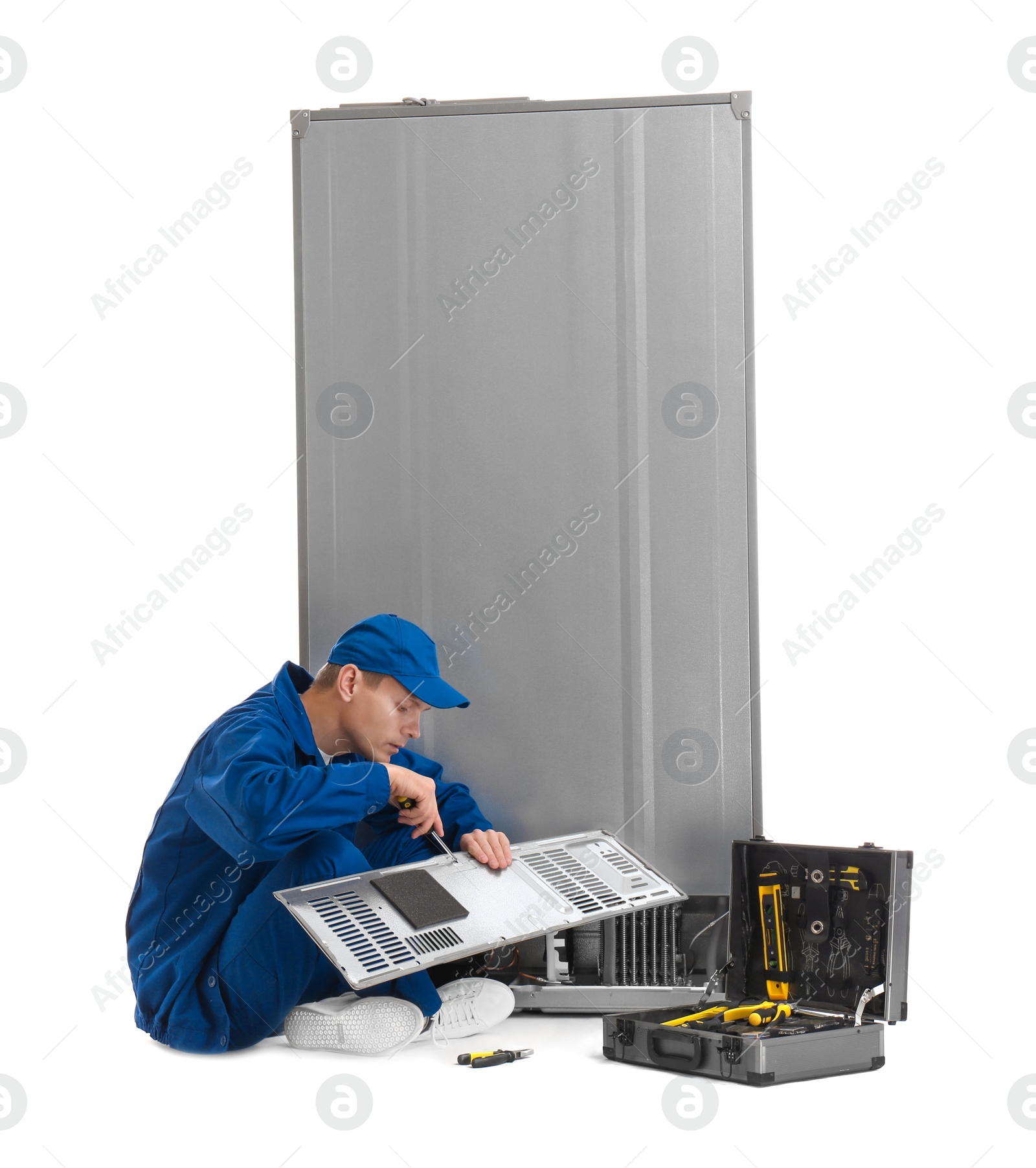 Photo of Male technician repairing refrigerator on white background