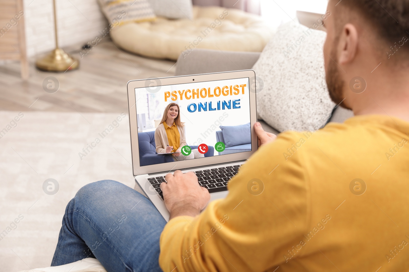 Image of Man using laptop at home for online consultation with psychologist via video chat, focus on screen