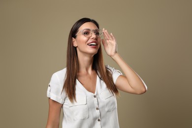 Photo of Beautiful woman in eyeglasses on beige background