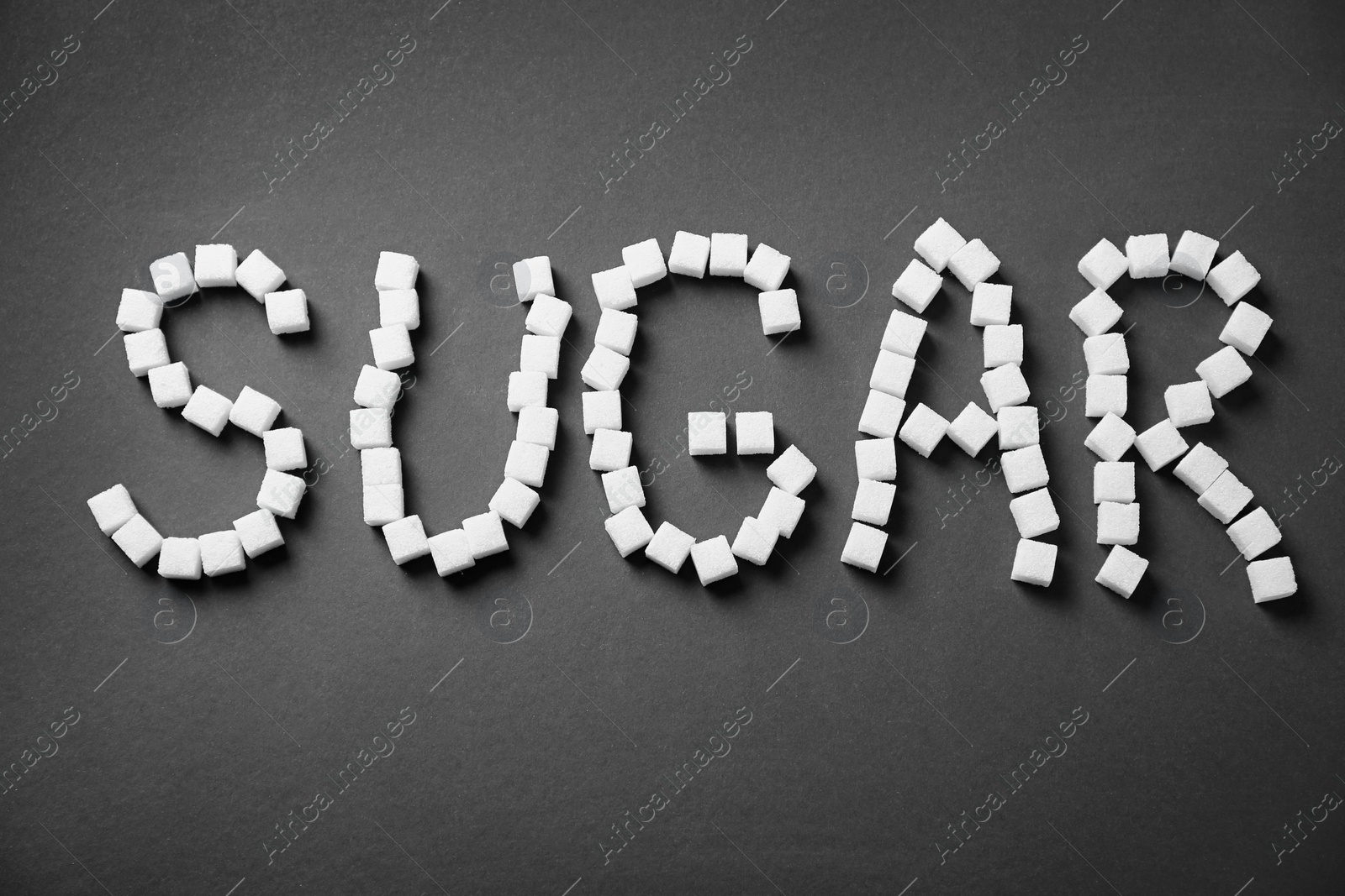 Photo of Word SUGAR on dark background