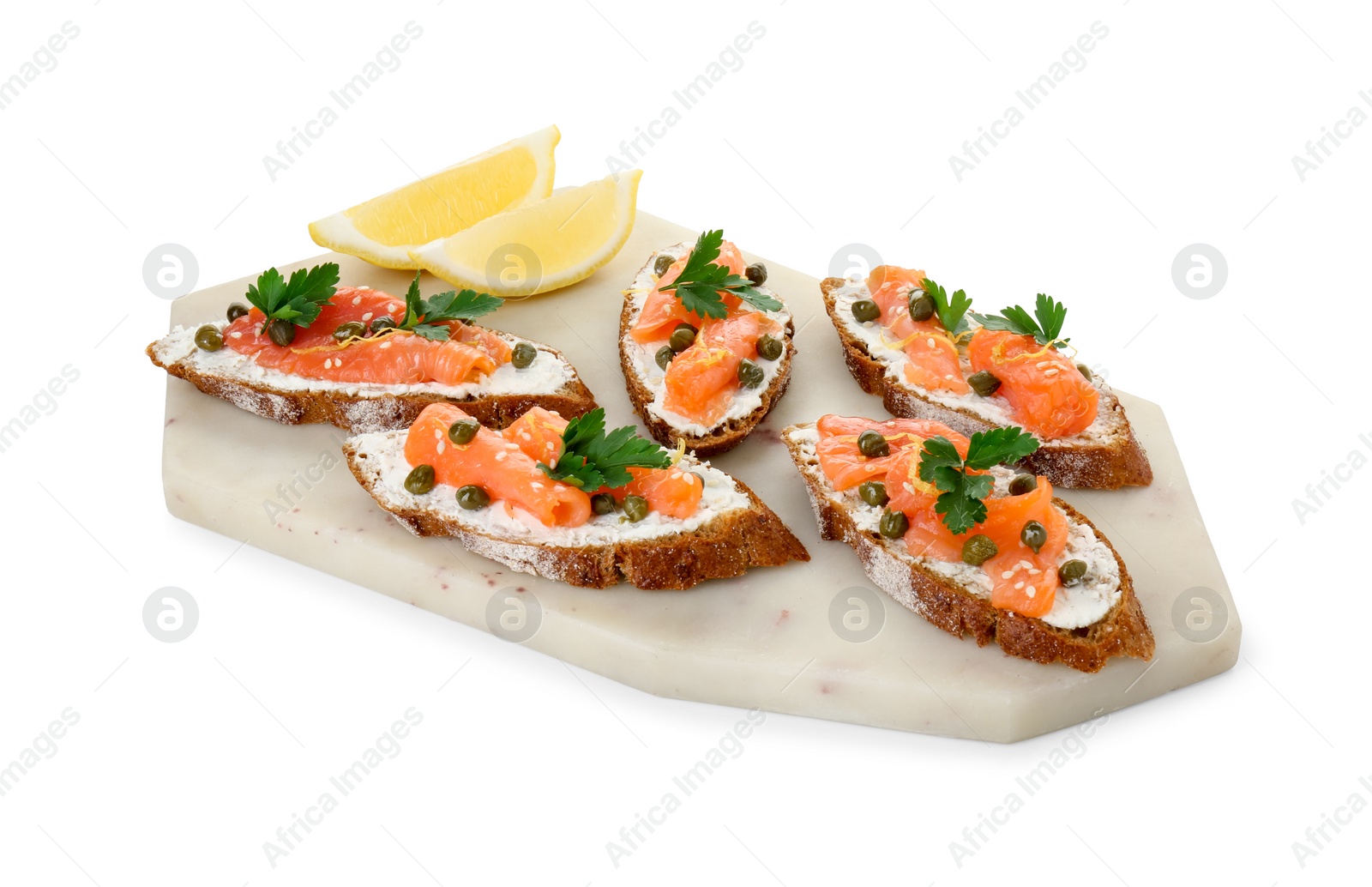 Photo of Tasty canapes with salmon, capers, lemon and cream cheese isolated on white