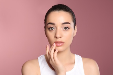 Young woman with sexy lips on color background