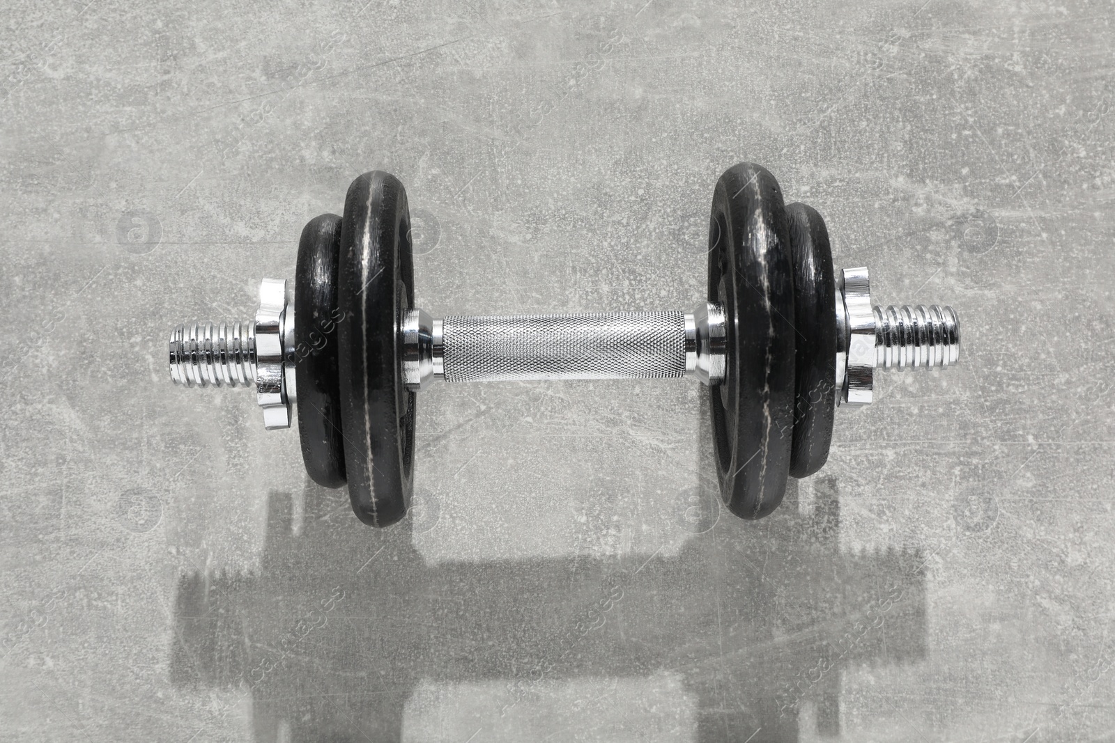 Photo of One barbell on grey textured background, top view