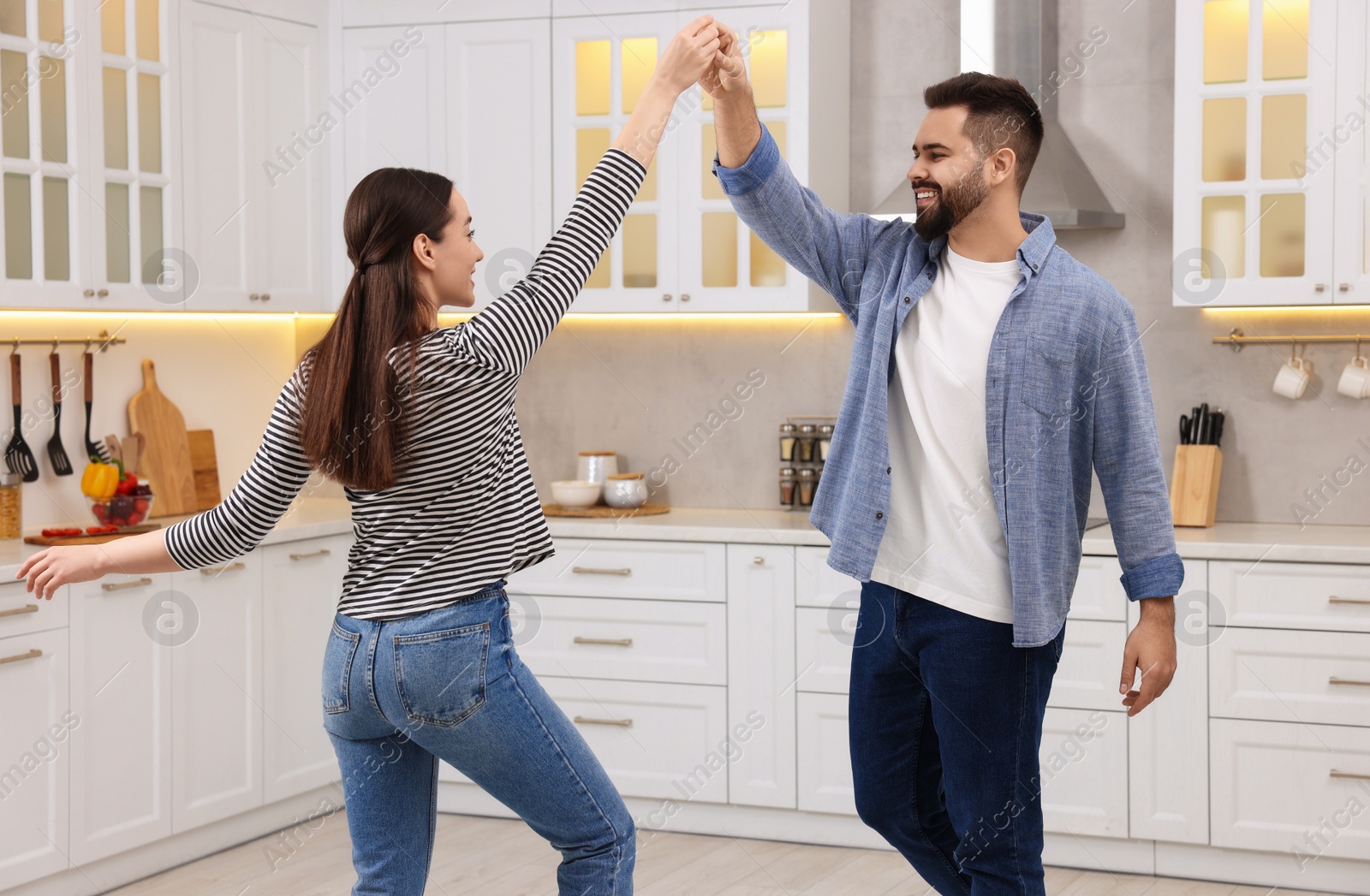 Photo of Happy lovely couple dancing together in kitchen