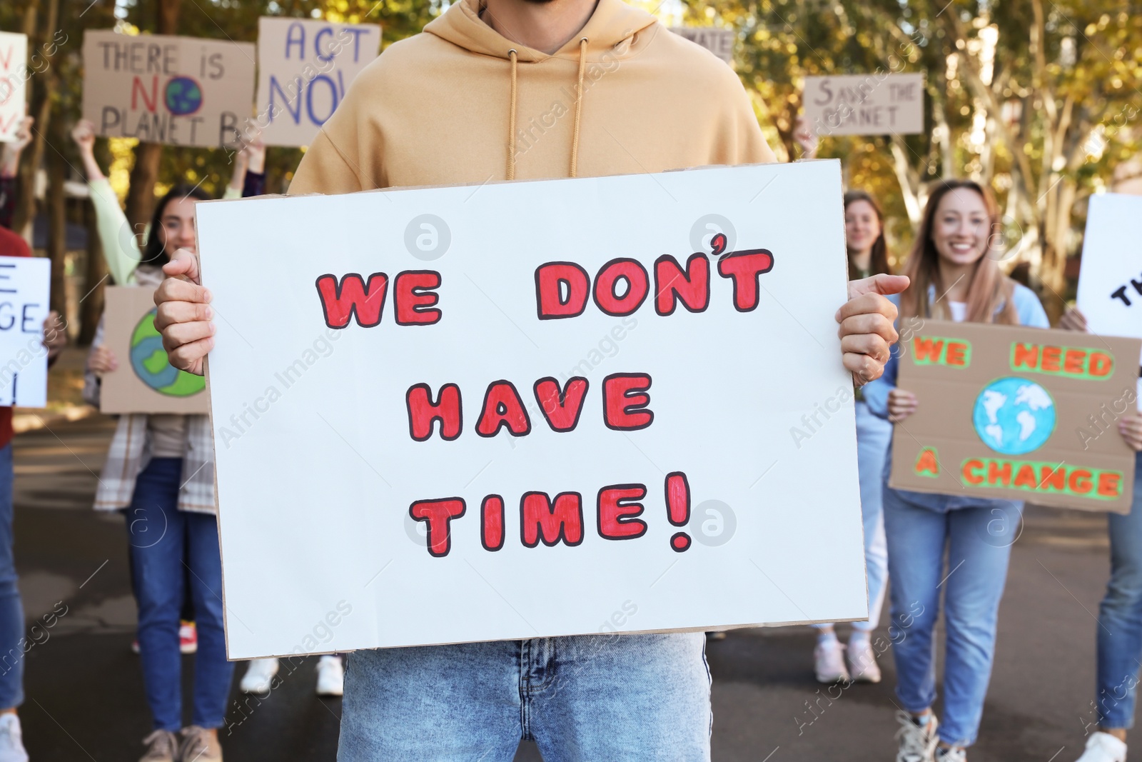 Photo of Group of people with posters protesting against climate change on city street, closeup