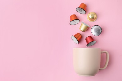 Photo of Many coffee capsules and cup on pink background, top view. Space for text