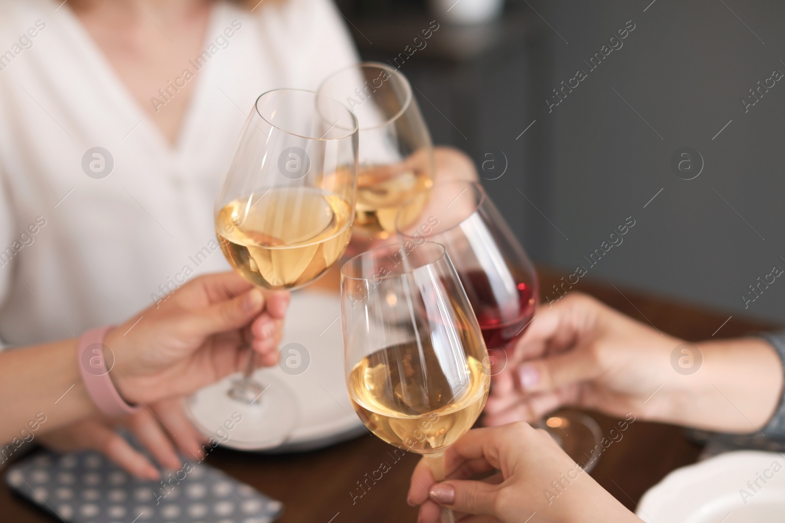 Photo of Young people with glasses of delicious wine at table