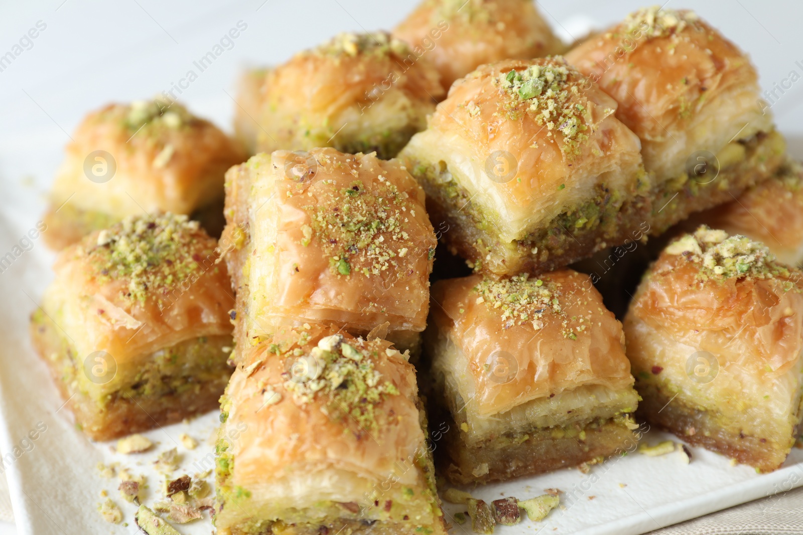 Photo of Delicious fresh baklava with chopped nuts on plate, closeup. Eastern sweets