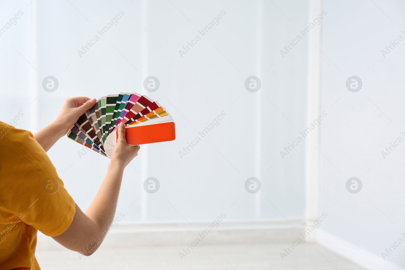 Photo of Female interior designer with color palette samples indoors, closeup. Space for text