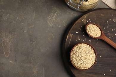 Photo of Bowl and spoon with white quinoa on grey table, flat lay. Space for text