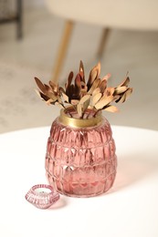 Photo of Vase with beautiful dried leucadendron plants and candle on white table in room