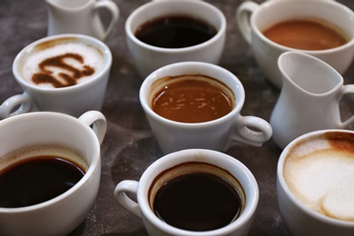 Photo of Cups of fresh aromatic coffee on grey background