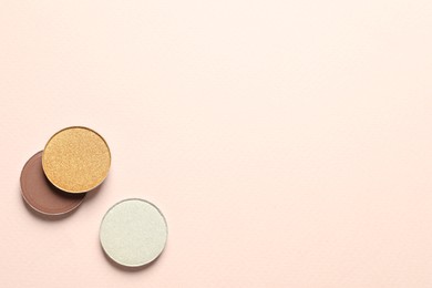 Different beautiful eye shadows on beige background, flat lay. Space for text