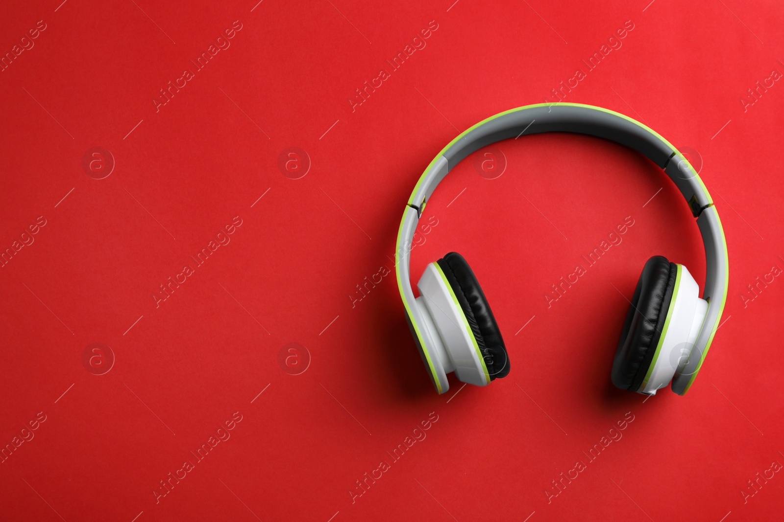 Photo of Wireless headphones on color background, top view. Space for text