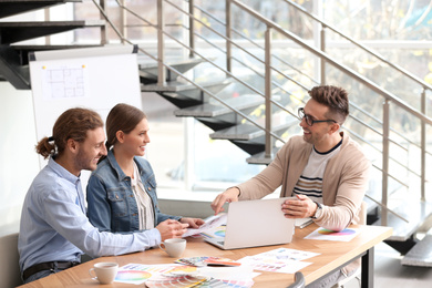 Interior designer consulting young couple in office