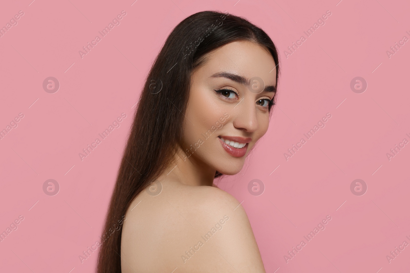 Photo of Portrait of beautiful young woman with elegant makeup on pink background