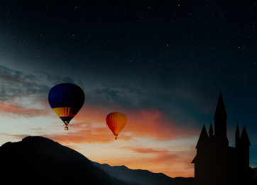 Image of Fairy tale world. Hot air balloons flying near hideaway castle in mountains