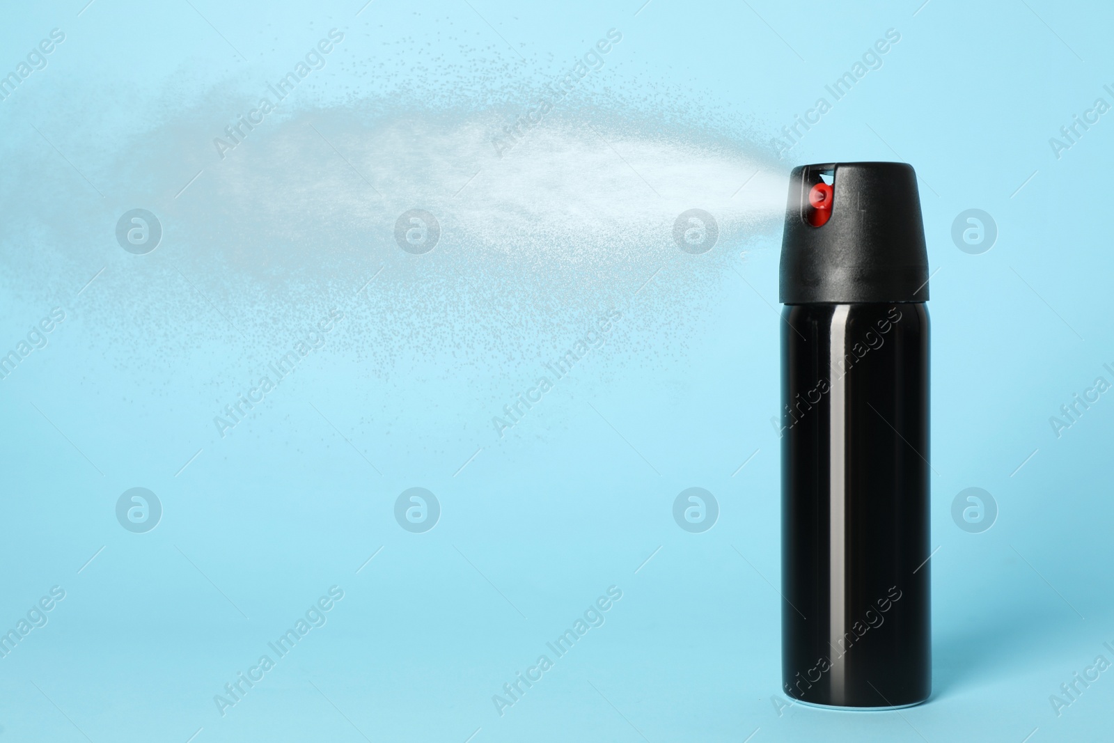 Image of Using of pepper spray on light blue background