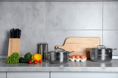 Set of different cooking utensils and products on grey countertop in kitchen. Space for text