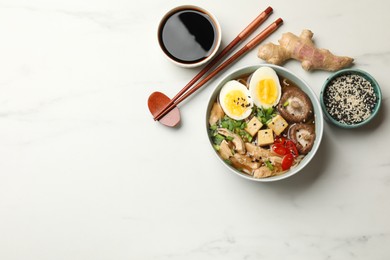 Photo of Delicious ramen served on white table, flat lay with space for text. Noodle soup