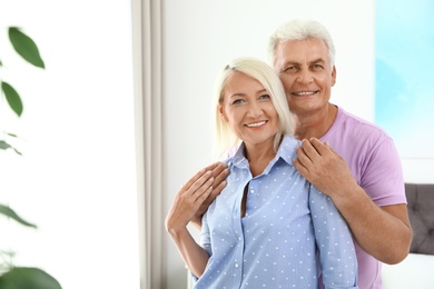 Photo of Portrait of happy senior couple at home. Space for text