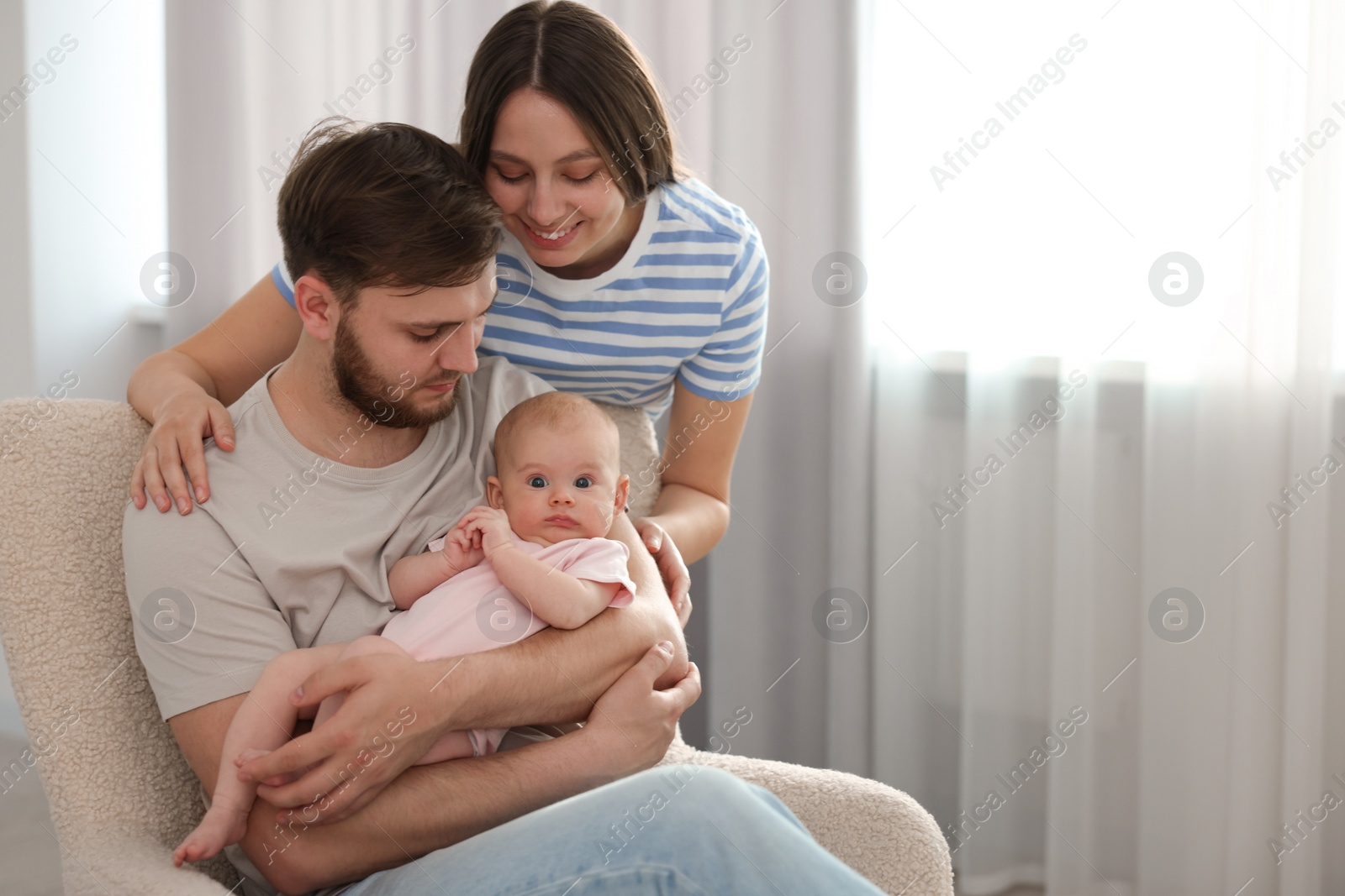 Photo of Happy family. Parents with their cute baby at home, space for text