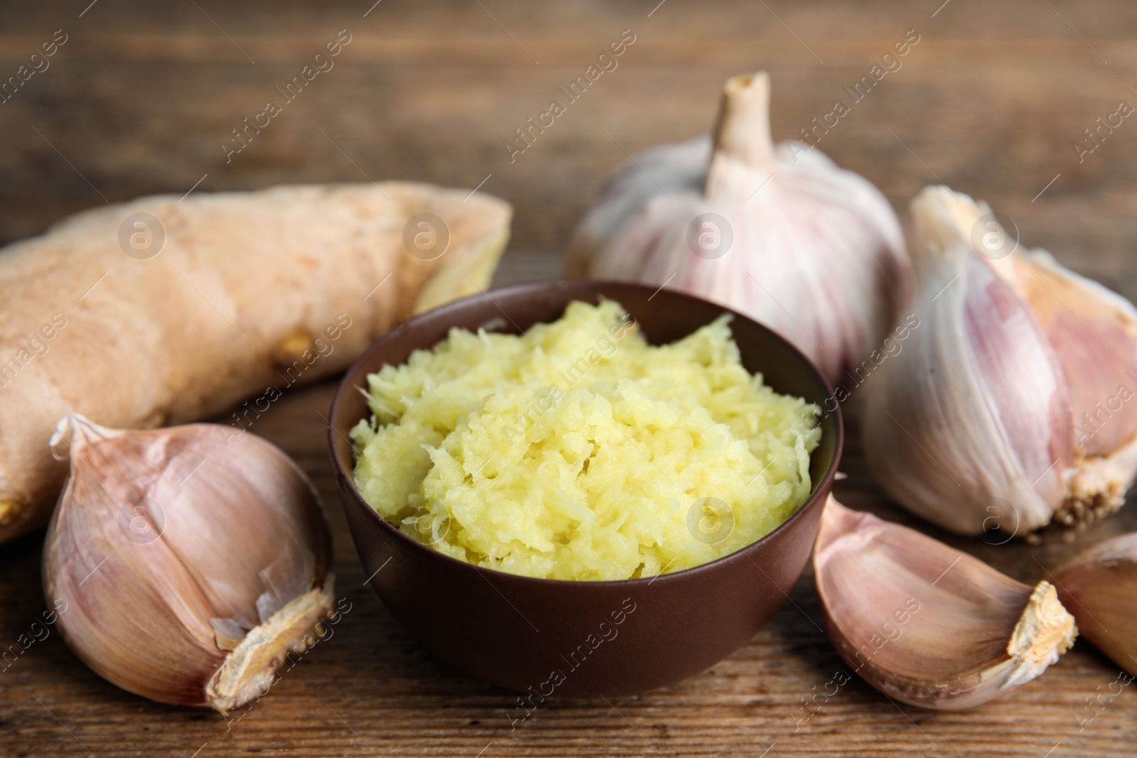 Photo of Fresh garlic and ginger on wooden table. Natural cold remedies