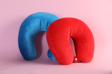 Photo of Light blue and red travel pillows on pink background