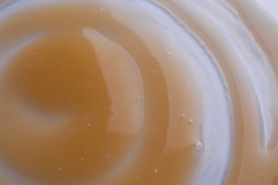 Photo of Brown shower gel on white background, closeup