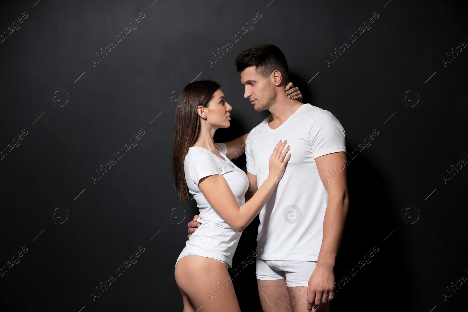Photo of Young couple wearing underwear on black background