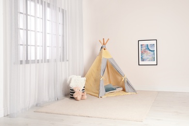 Photo of Cozy child room interior with play tent near window