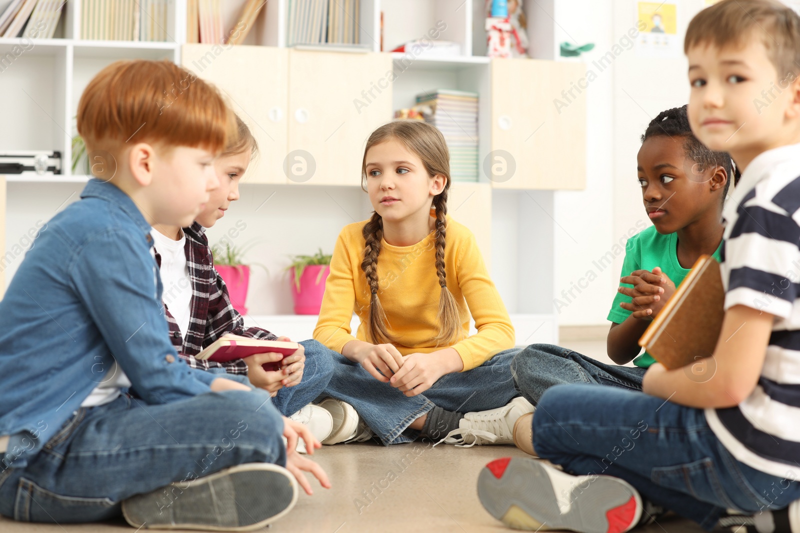 Photo of Cute children discussing in classroom at school