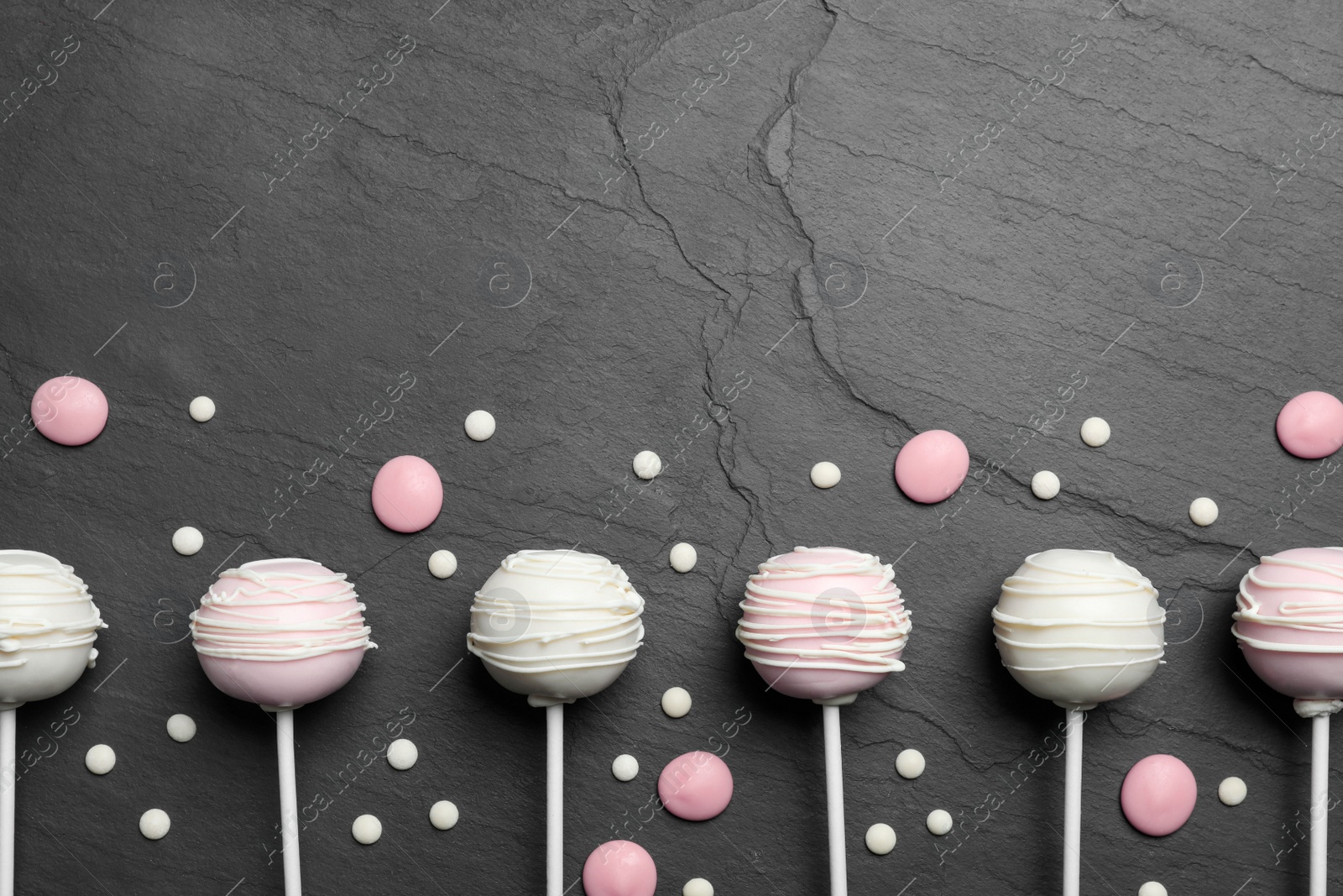 Photo of Flat lay composition with sweet cake pops on black background. Space for text